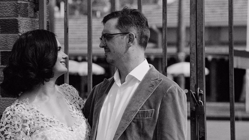 A timeless black and white film portrait of a bride and groom, featuring rich silvery tones and deep contrast that emphasizes their authentic connection.