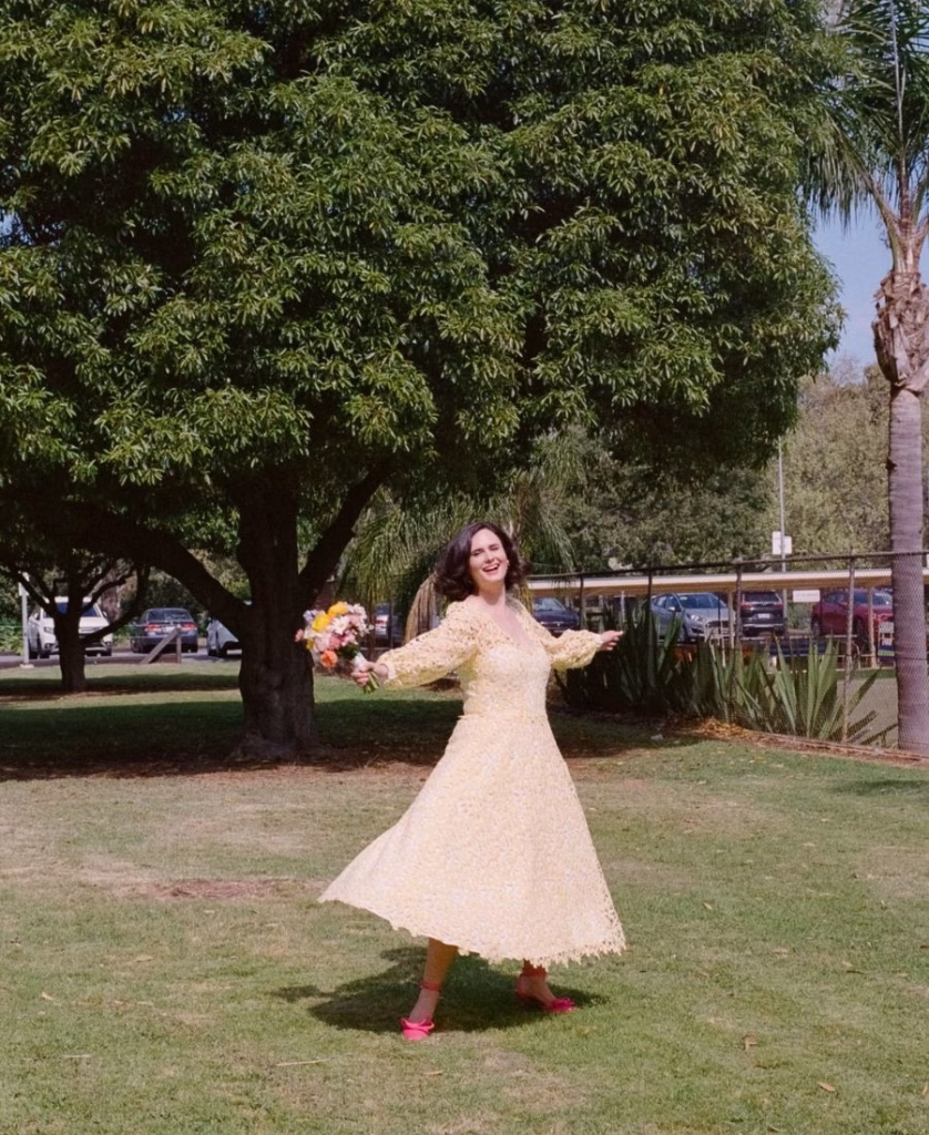 A joyful film photograph of a bride dancing with her bouquet at the Adelaide Bowling Club, captured with soft motion blur and warm golden hour light to highlight the unscripted energy of the moment by Phoebe Kate Photography.